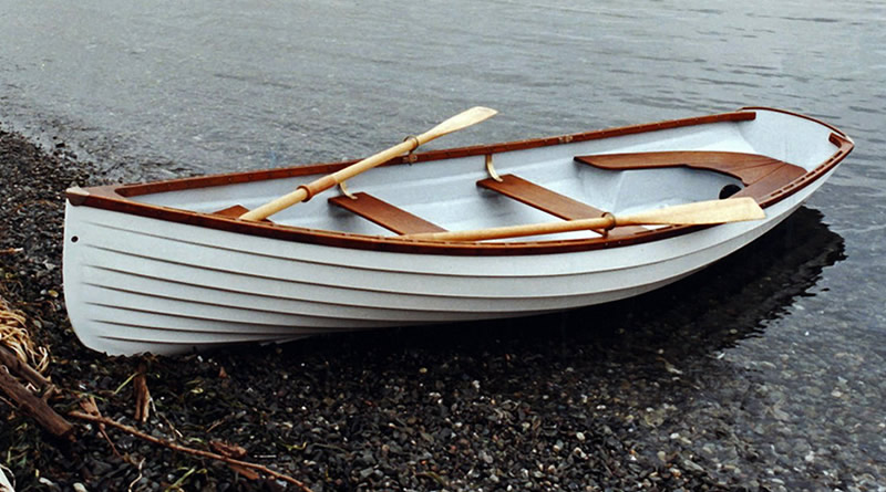 A popular activity for beginners, a wooden boat on the shore of a body of water.