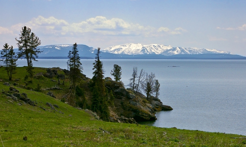 Yellowstone lake with snow capped mountains in the background.
